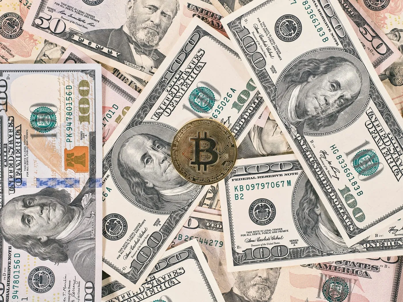 Physical coins representing several cryptocurrencies arranged on a dark surface
